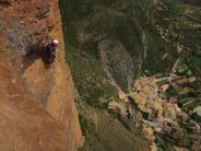 Climbers high above Riglos village on the Murciana route