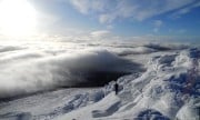 Summit of Ben Rinnes in winter looking down on the clouds
