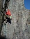 1st ascent: Using a slippery jam to reach holds on the first ledge