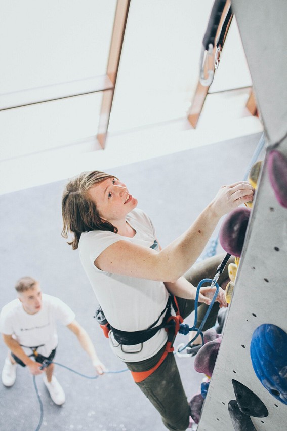 Lead climbing: clipping the rope into safety points as you climb. A belayer catches the climber in the event of a fall.  © Sam Scriven