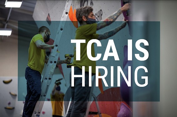 TCA is hiring written over a picture of 2 route setters working in a climbing wall   © The Climbing Academy